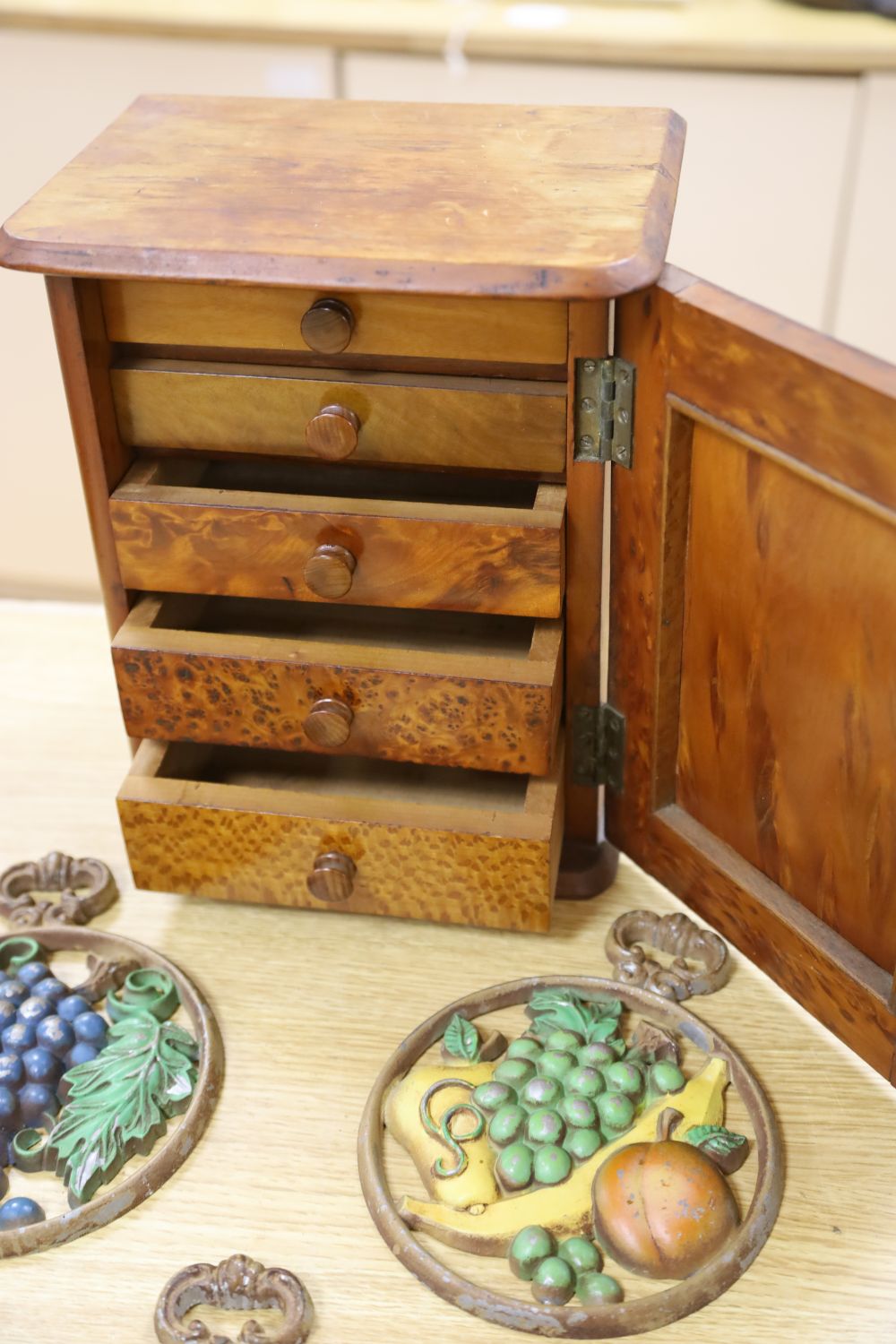 A late Victorian burr yew table-top cupboard, with five enclosed drawer veneered in a variety of timbers, width 22cm, and three cast